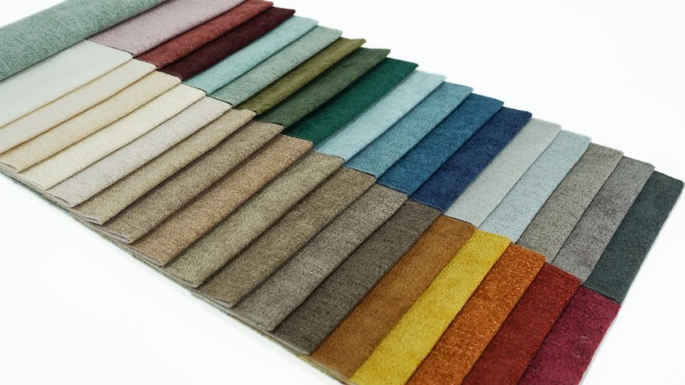 A multi-layered stack of polyester chenille swatches in vibrant colors
